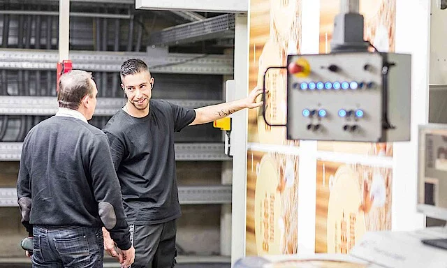 Two colleagues at a flexo printing machine.