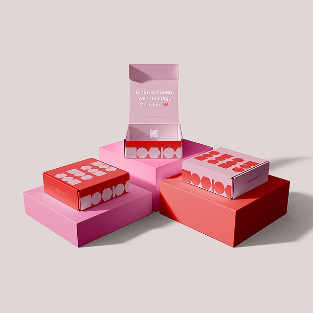 Personalised packaging stacked in red and pink.