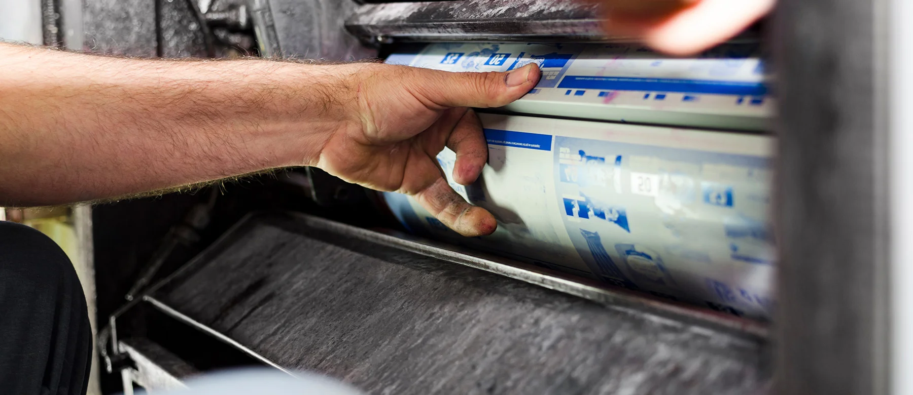 A printing plate is clamped in the machine.